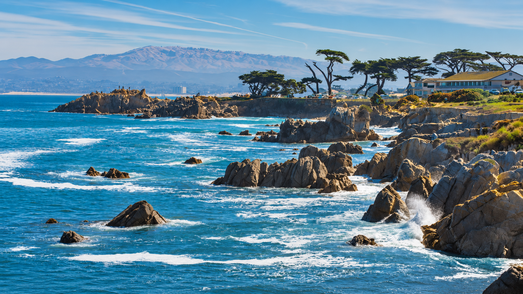 Rocky Monterey Bay coastline with ocean waves and cypress trees